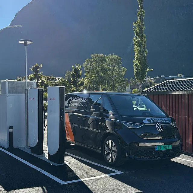 Svart varebil står på elbil ladestasjon