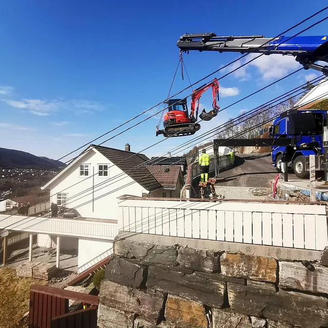 Lastebil med lift heiser gravemaskin