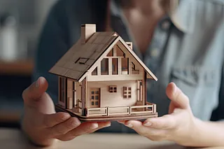 Modellhus i tre holdes i hender